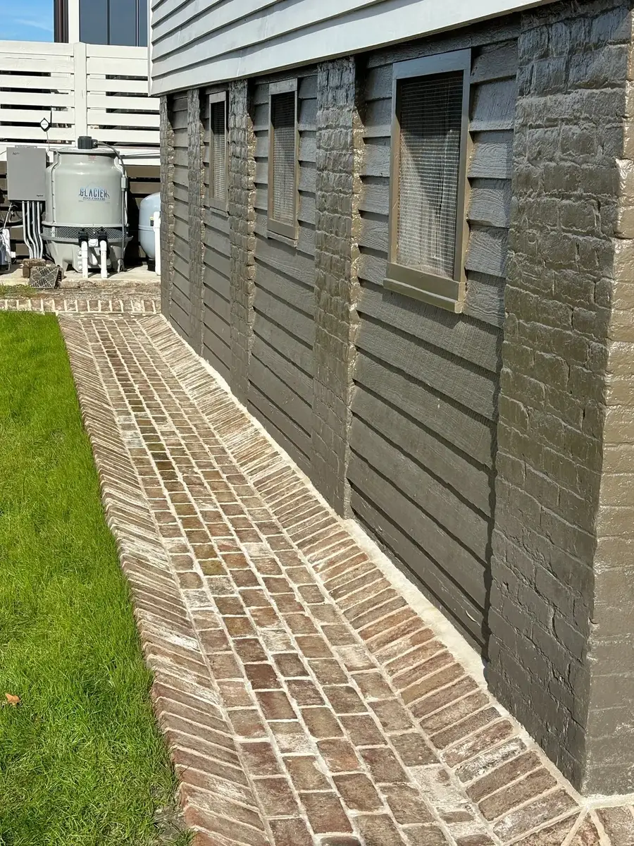 Straight brick edging creates a clean boundary beside a home