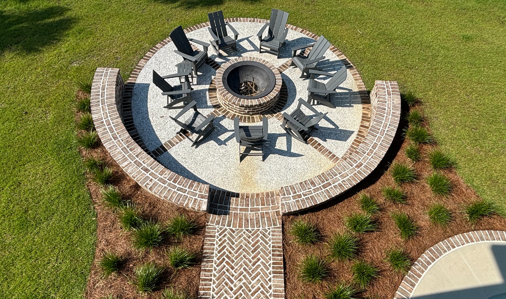 Stone fire pit and outdoor gathering space surrounded by Lowcountry landscaping