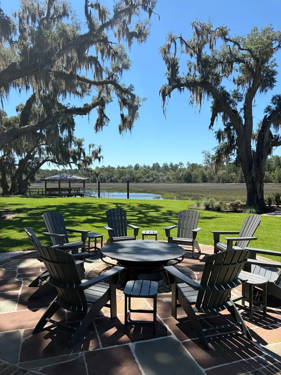Outdoor gathering space framed by palms, lawn and landscape beds